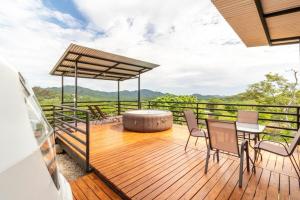 a deck with a table and chairs and a view at Glamping en Playa Potrero in Potrero