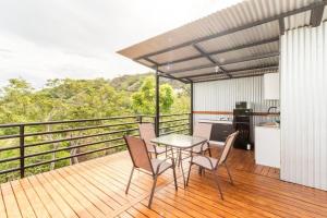 a balcony with a table and chairs on a deck at Glamping en Playa Potrero in Potrero