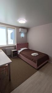 1 dormitorio con cama, mesa y ventana en Гостьовий Будинок Апартаменти в тихому центральному районі Полтави Смарт-квартири, en Poltava