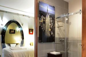 a bathroom with a shower and a bed and a mirror at Hotel de la muraille de sens in Sens