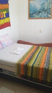 a bed with a colorful blanket on top of it at Pousada Encantadas in Pontal do Paraná