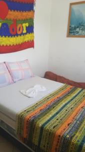 a bed with a colorful blanket on top of it at Pousada Encantadas in Pontal do Paraná