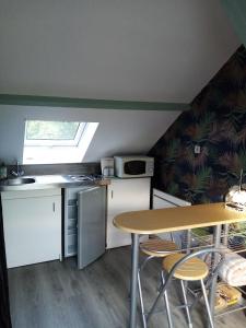 een kleine keuken met een tafel en een raam bij Petit Studio Mansardé - accès indépendant in Neuilly