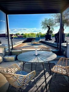 a patio with a table and chairs and a view of the water at Luxus Loft über den Dächern von Roding in Roding