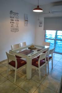 stół jadalny z krzesłami i szklanym blatem w obiekcie Amplio Dpto s/Av Rafael Nuñez - cerro de las rosas w Córdobie