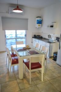 una sala da pranzo con tavolo e sedie e una cucina di Amplio Dpto s/Av Rafael Nuñez - cerro de las rosas a Córdoba