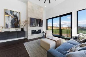 a living room with a blue couch and large windows at ZION TREASURE - RUBY at Copper Rock! in Hurricane