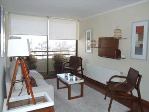 sala de estar con sofá, mesa y sillas en bellavista Departamento Amoblado, en Santiago