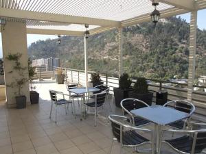 un patio con mesas y sillas en el balcón en bellavista Departamento Amoblado, en Santiago