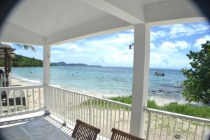 - une vue sur la plage depuis la terrasse couverte d'une maison dans l'établissement TI PARADIS DE l'ANSE FIGUIER VILLA voir site vacances en martinique, à Rivière-Pilote