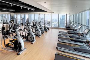 a gym with rows of exercise bikes and treadmills at Renaissance Shenzhen Bay Hotel in Shenzhen