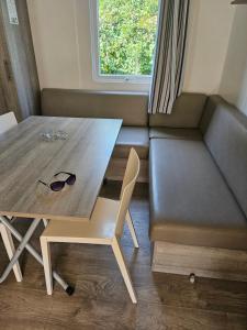 a small living room with a table and a couch at Mobil-home climatisé (proximité EUROPA PARC) in Boofzheim