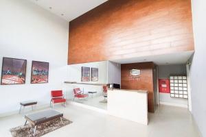 a lobby with chairs and a counter in a building at Encantador Refúgio Completo e Bem Localizado in Campos dos Goytacazes