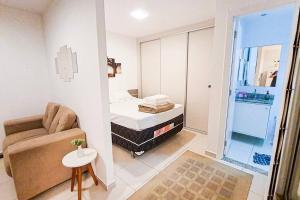 a small living room with a bed and a chair at Encantador Refúgio Completo e Bem Localizado in Campos dos Goytacazes