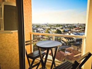 a table and chairs on a balcony with a view at Encantador Refúgio Completo e Bem Localizado in Campos dos Goytacazes