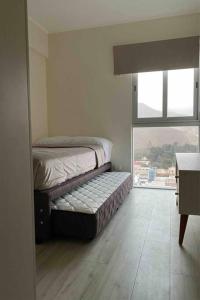 two beds in a room with a window at Dpto con hermosa vista al hipódromo de Monterrico in Lima