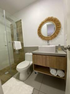 a bathroom with a toilet and a sink and a mirror at Dpto con hermosa vista al hipódromo de Monterrico in Lima