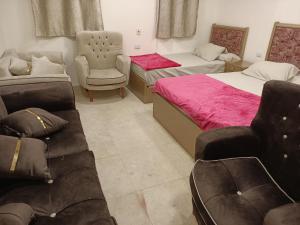 1 Schlafzimmer mit 2 Betten, einem Stuhl und einem Sofa in der Unterkunft El jawhra house in Kairo
