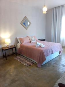 a bedroom with a bed with a teddy bear on it at Chalézinho Santorini in Guararema