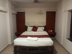 1 dormitorio con 1 cama grande en una habitación en Vel Residency, en Thanjāvūr