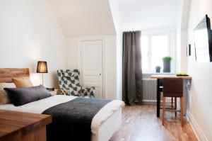 a bedroom with a bed and a desk and a chair at Continental Apartment Hotel Sundsvall in Sundsvall