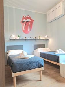 twee bedden in een kamer met een mond aan de muur bij Music Apartment in Beinette