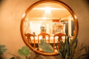 a mirror reflecting a room with chairs in it at La Casa De Jardin in Luang Prabang