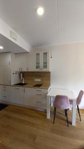 uma cozinha com uma mesa branca e uma cadeira em Lutsu 12 Apartment - Self check-in em Tartu