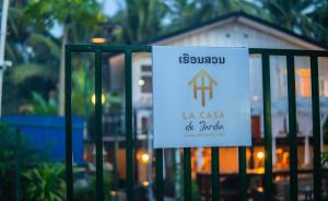 a sign on a gate in front of a house at La Casa De Jardin in Luang Prabang