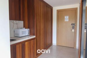 a kitchen with a microwave on a counter next to a door at Qavi - Luxo Rua Principal de Pipa #ÎledePipa in Pipa