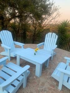 two white chairs and a table and a table and chairs at JB Countrylife Accommodation in Koedoe