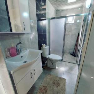 un bagno con lavandino, WC e doccia di OLYMPOS YÖRÜK OTAĞI APART EVLERİ a Kumluca