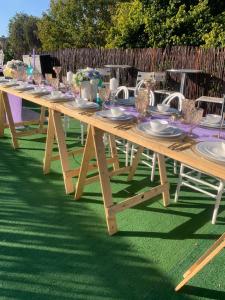 una mesa de picnic de madera con platos y vasos. en JB Countrylife Accommodation, en Koedoe