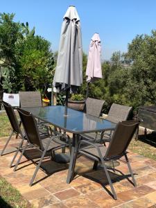 una mesa con sillas y una sombrilla en el patio en JB Countrylife Accommodation, en Koedoe