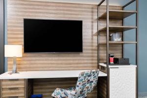 a room with a desk with a tv on a wall at Marriott Anchorage Downtown in Anchorage