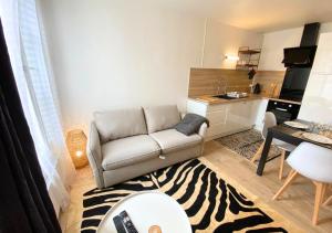 ein Wohnzimmer mit einem Sofa und einem Zebra-Teppich in der Unterkunft A l'Université - Poitiers - La Conciergerie. in Poitiers
