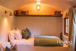 a bedroom with a bed in a tiny house at Red Kite Retreat - Bluebell - Shepherds Hut 1 in Henley on Thames