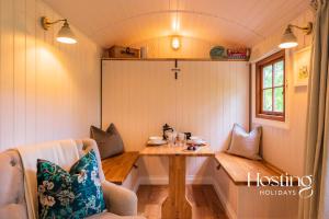 a small room with a table in a tiny house at Red Kite Retreat - Bluebell - Shepherds Hut 1 in Henley on Thames