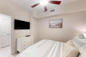 a bedroom with a bed and a ceiling fan at Sea Glass 208 in Gulf Shores