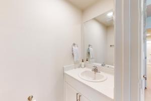 a white bathroom with a sink and a mirror at Sea Glass 208 in Gulf Shores +13 photos