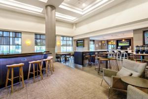 um átrio com um bar, mesas e cadeiras em SpringHill Suites by Marriott Miami Airport South Blue Lagoon Area em Miami