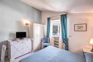 a bedroom with a bed and a desk with a computer at Palatium Mari in Capri +173 photos