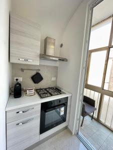a kitchen with a stove top oven next to a window at Casa vacanza l’archetto in Genzano di Roma +7 photos