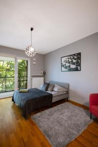 1 dormitorio con 1 cama y 1 silla roja en ClickTheFlat Artistic Estate Apartment en Varsovia