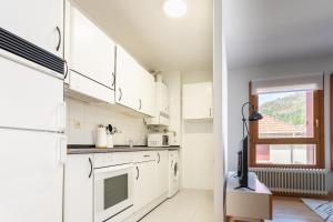 a kitchen with white cabinets and a window at Orhitxikina in Ochagavía