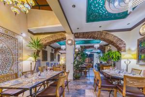 un comedor con mesas y sillas y un arco en Casa Riad Yasmin en Silves