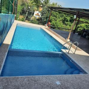 a swimming pool with blue water and a ramp at Hotel & Hostal Mayflower in Puerto Escondido