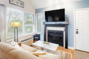 a living room with a couch and a fireplace at Condo 416 at North Creek Resort in Blue Mountains
