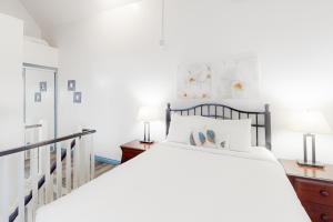 a white bedroom with a bed and two lamps at Condo 416 at North Creek Resort in Blue Mountains +22 photos