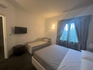 a hotel room with two beds and a window at Acquamarina Luxury Rooms in Budoni